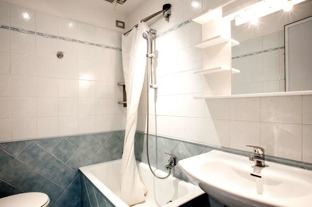 A modern bathroom with a shower, a sink, and a toilet.