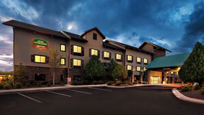 Un hotel Courtyard by Marriott con estacionamiento, varias edificaciones y techo verde.