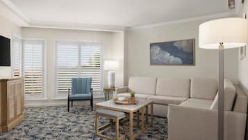 A living room with a sofa, a chair, a coffee table, and a lamp.