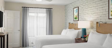 Ein Hotelzimmer mit zwei Betten, einem Deckenventilator, einer weißen Ziegelwand und einem Fenster mit Vorhängen.