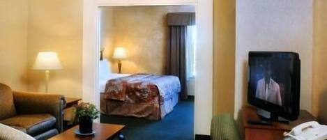 A hotel room with a bed, a television, a desk, and a chair.