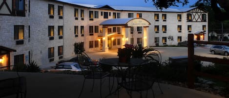 A hotel with a stone facade, multiple windows, and a sign reading "Baron's Creek".