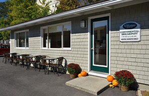 A motel with a Continental Breakfast sign, outdoor seating, and seasonal decorations. - Bar Harbor Villager Motel - Downtown (Bar Harbor)