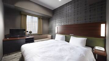 A hotel room with a large bed, a TV on a wooden console, a bedside phone, and a window with curtains.