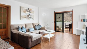 A living room with a sofa, coffee table, and a painting on the wall. - Paloma Beach Apartments (Arona)