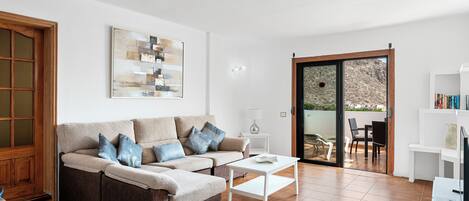 A living room with a sofa, coffee table, and a painting on the wall.