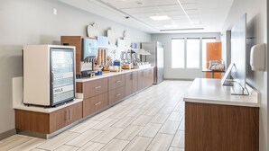 Een moderne keuken met een koelkast, magnetron en koffieapparaat.