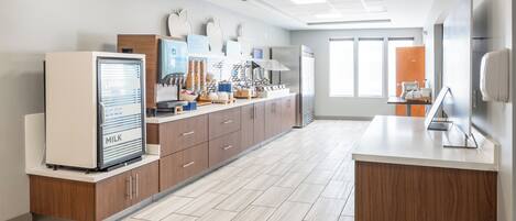 A modern kitchen with a refrigerator, microwave, and coffee machine.