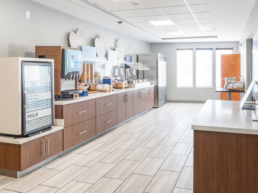 A modern kitchen with a refrigerator, microwave, and coffee machine.