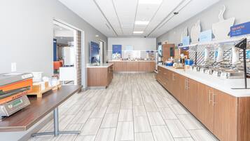 A modern kitchen with a flat-screen TV, a coffee machine, and a breakfast bar.