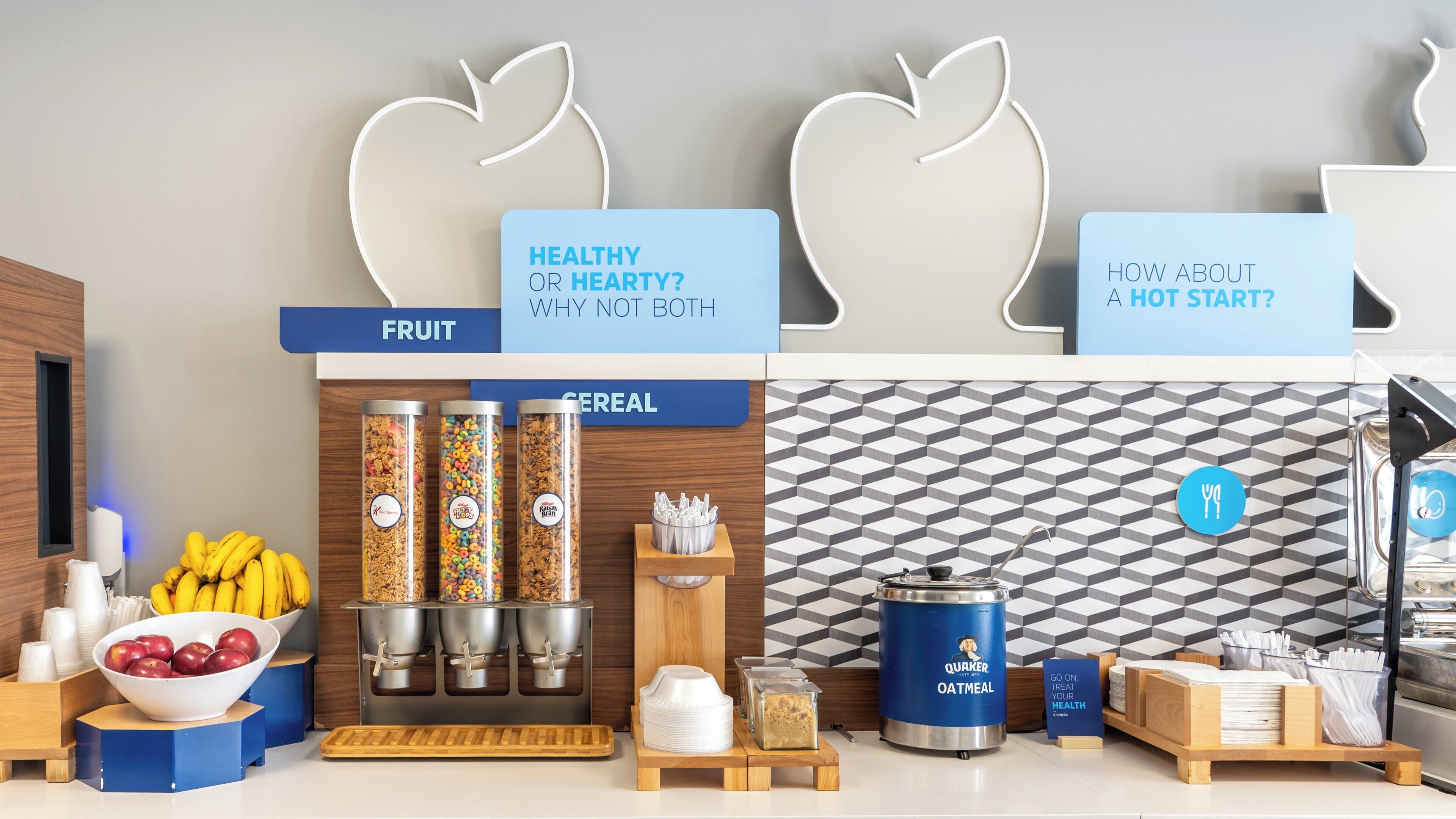 A breakfast bar with fruit, cereal, and oatmeal options, and signs promoting healthy eating.