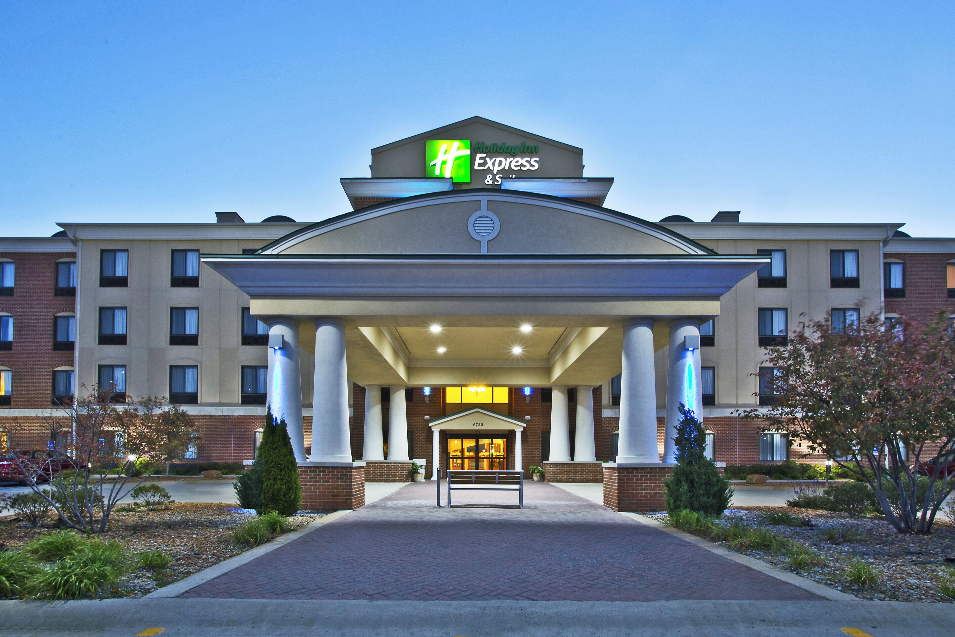 A Holiday Inn Express hotel entrance with a covered walkway, columns, and a brick facade.
