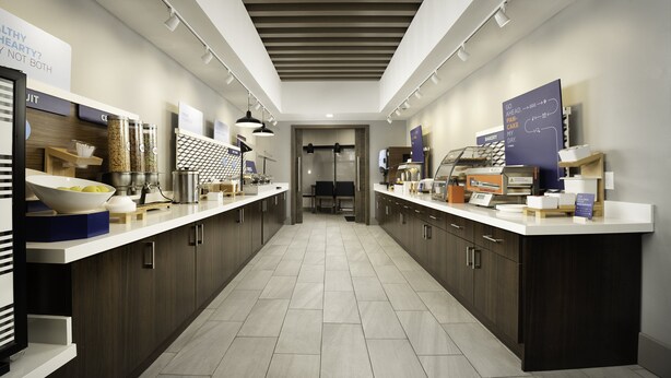A modern kitchen with a central island, built-in appliances, and a view into the dining area.