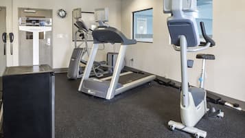 A fitness center with treadmills, a stationary bike, and a weight bench.