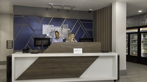 A reception desk with a modern design, a digital screen, and a sign indicating 'IHG' branding.