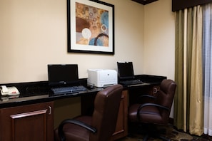 A hotel room with two desks, each with a laptop, a printer, and a telephone. There are two chairs and a door. - Holiday Inn Express and Suites Moultrie by IHG (Moultrie)