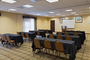 A conference room with tables and chairs, a whiteboard, and a door. - Holiday Inn Express and Suites Moultrie by IHG (Moultrie)