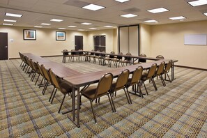 A conference room with a long table and chairs, carpeted floor, and ceiling lights. - Holiday Inn Express and Suites Moultrie by IHG (Moultrie)