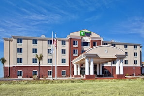 A Holiday Inn Express hotel with a central entrance, multiple floors, and a flagpole with the American flag. - Holiday Inn Express and Suites Moultrie by IHG (Moultrie)