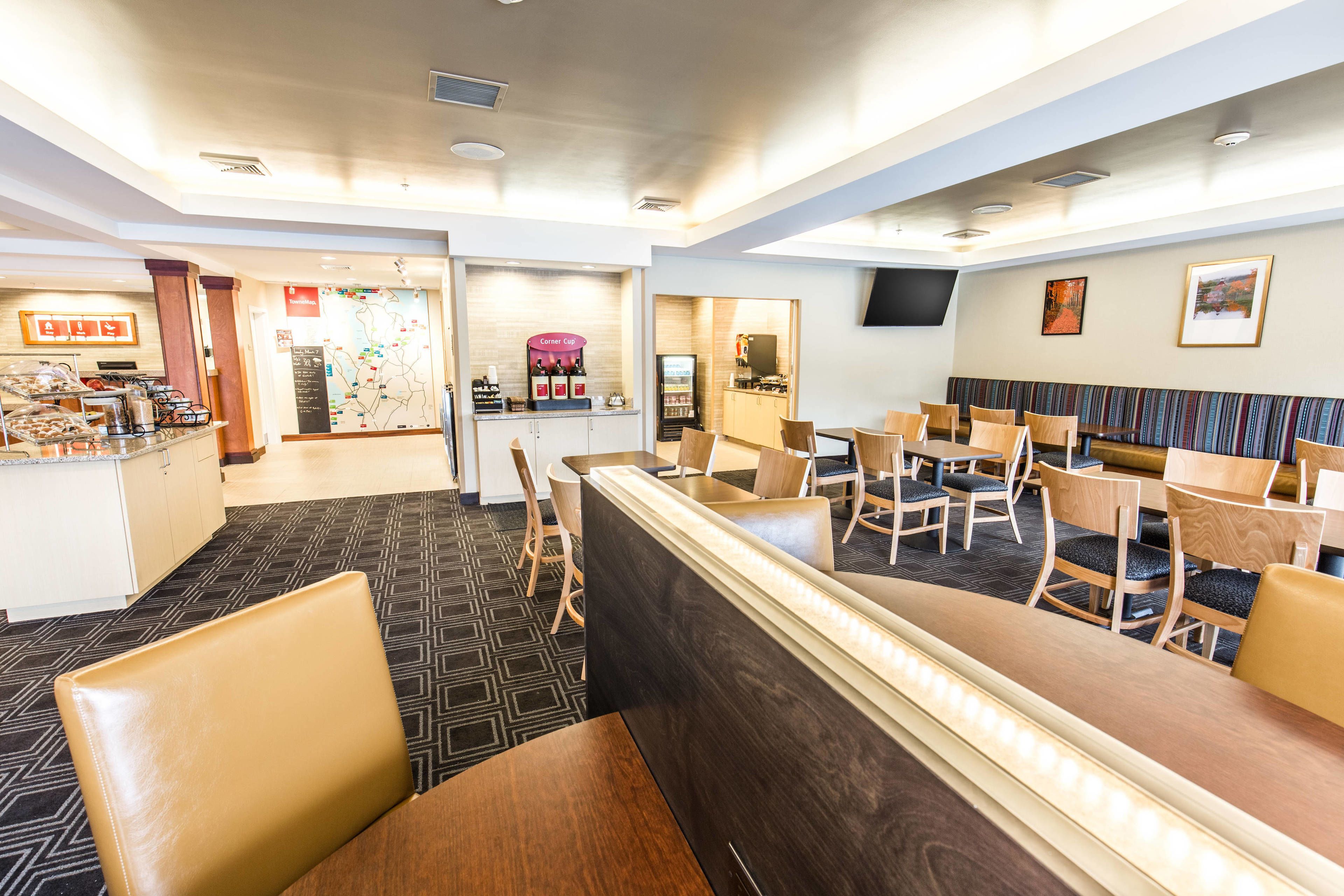 Een hotel lobby met receptiebalie, zithoek en koffiecorner.