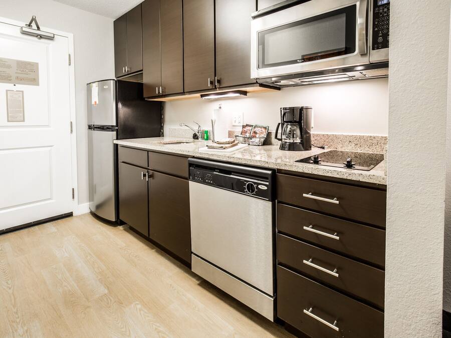 A modern kitchen with stainless steel appliances, a dishwasher, and a coffee maker.