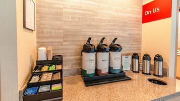Een zelfbedieningsdrankstation met dispensers met de aanduiding 'BOLD' en 'DECAY' in een hotellobby.