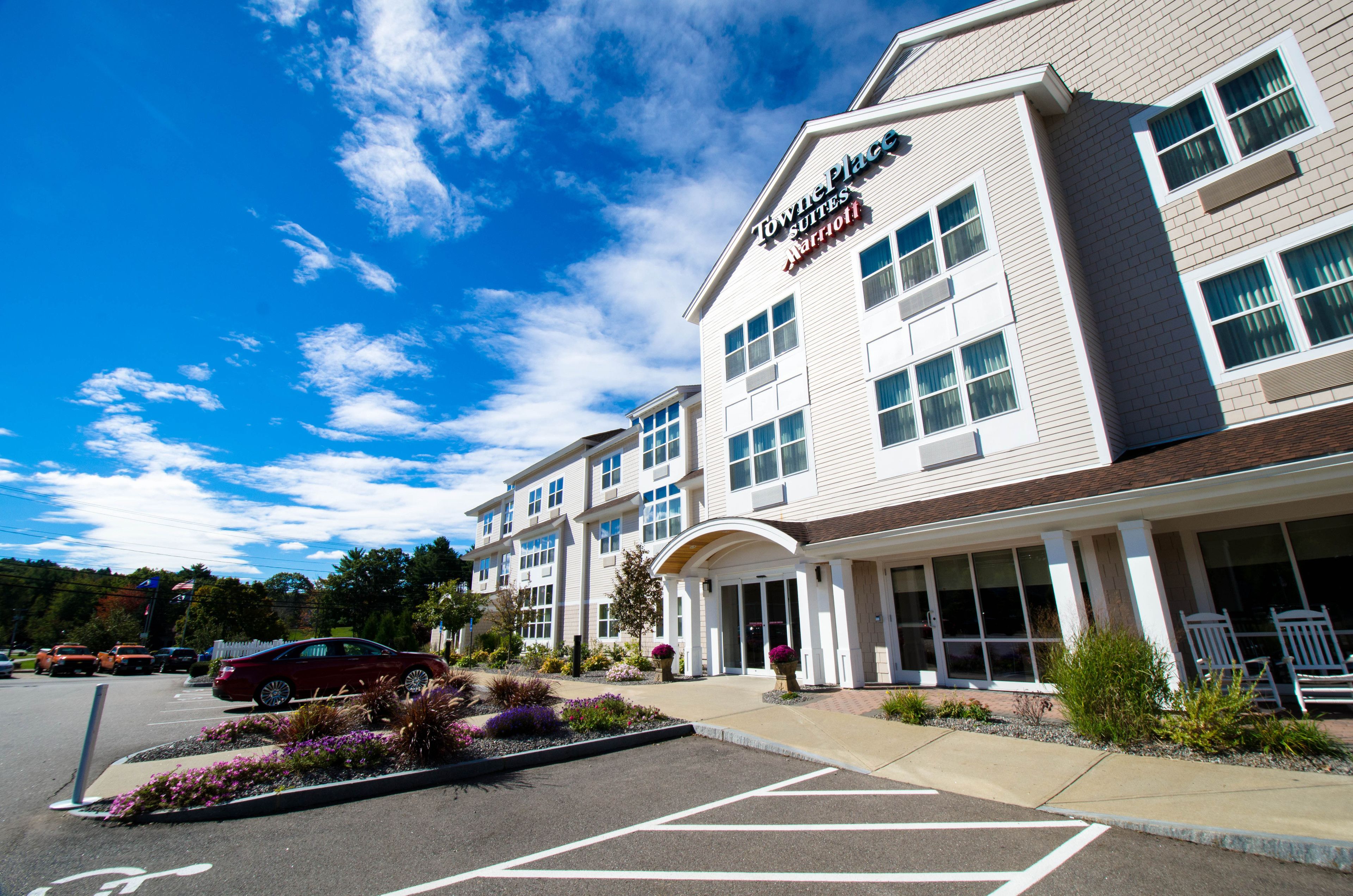 A hotel with a modern design, featuring a large entrance and a parking lot.