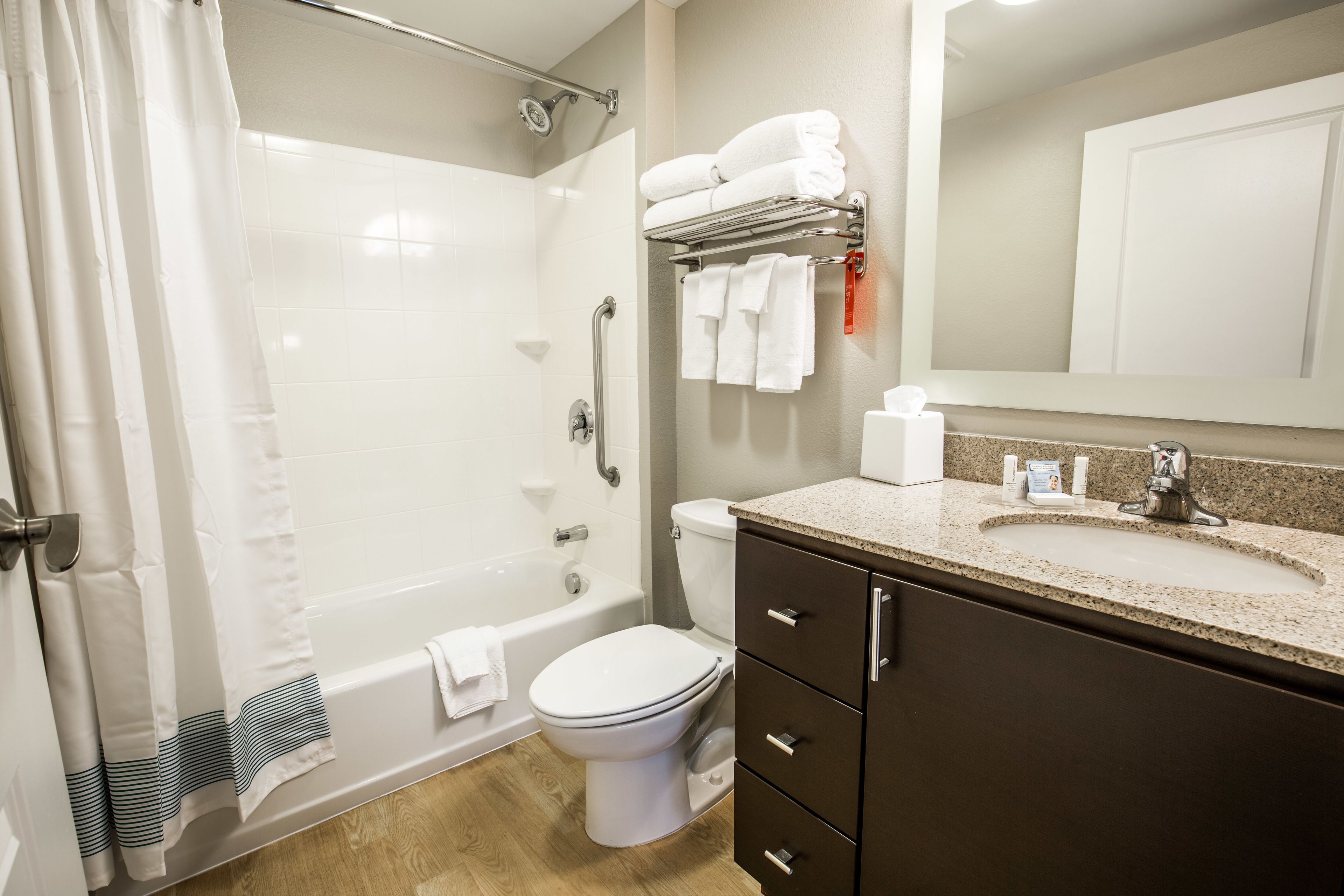 A modern bathroom with a bathtub, toilet, and vanity.