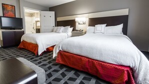 Une chambre d’hôtel avec deux lits, une télévision, un bureau et une salle de bain.