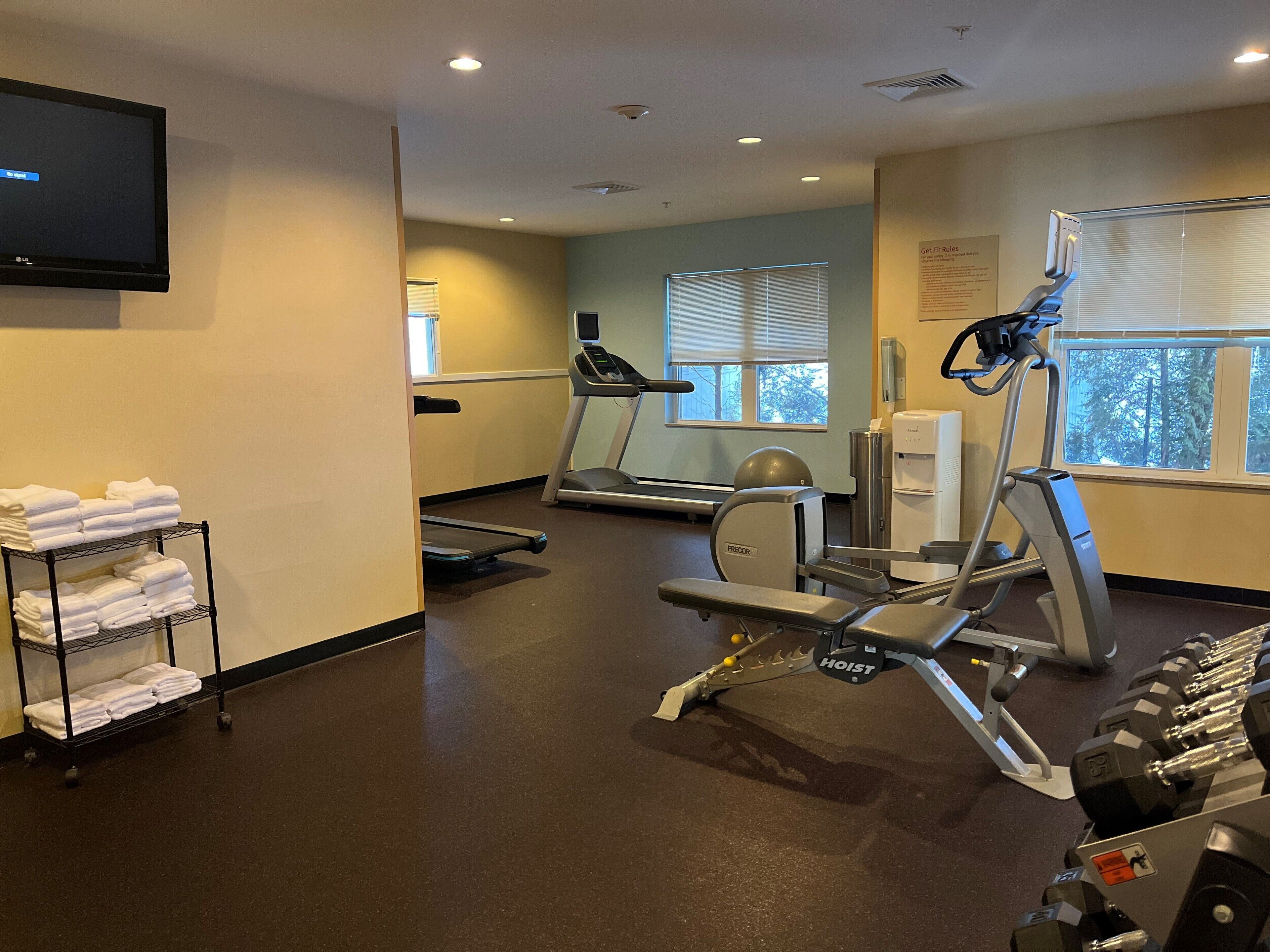 Un centre de remise en forme équipé de tapis de course, d’un vélo d’appartement et d’appareils de musculation.