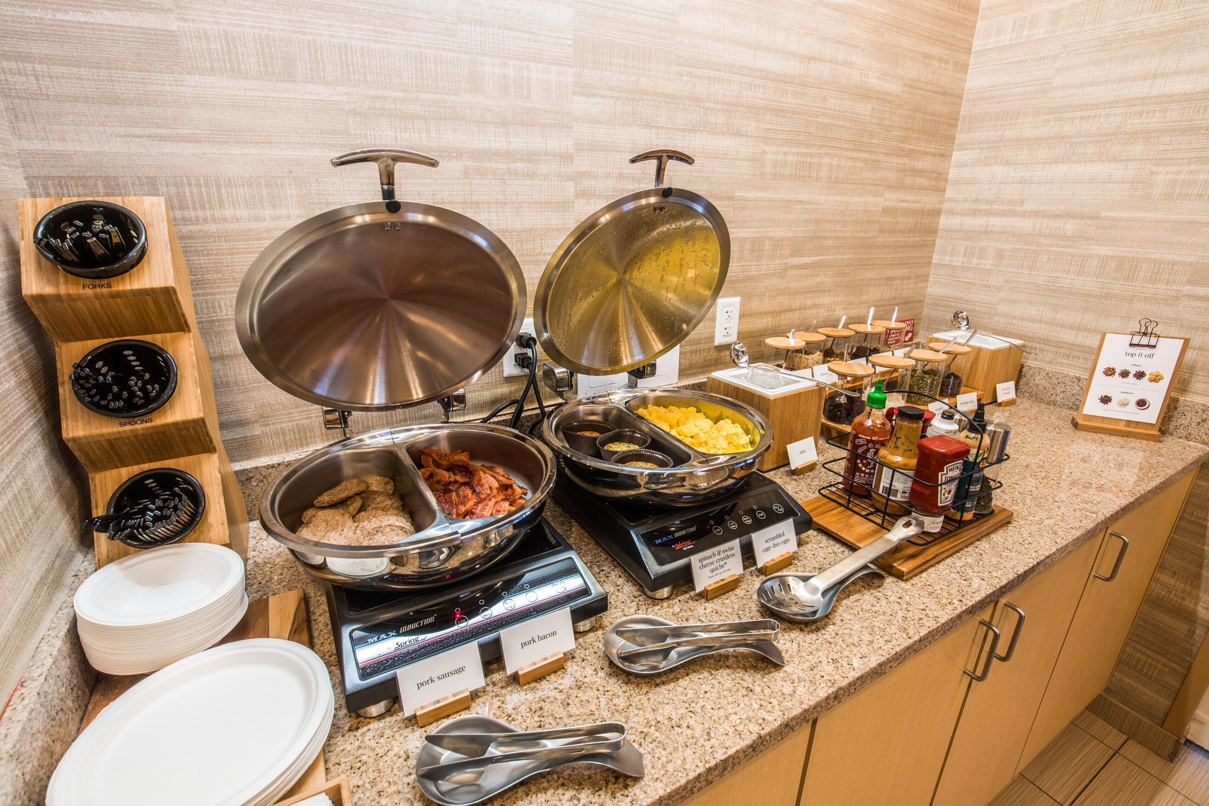 Una mesa de buffet con diversos alimentos y utensilios.