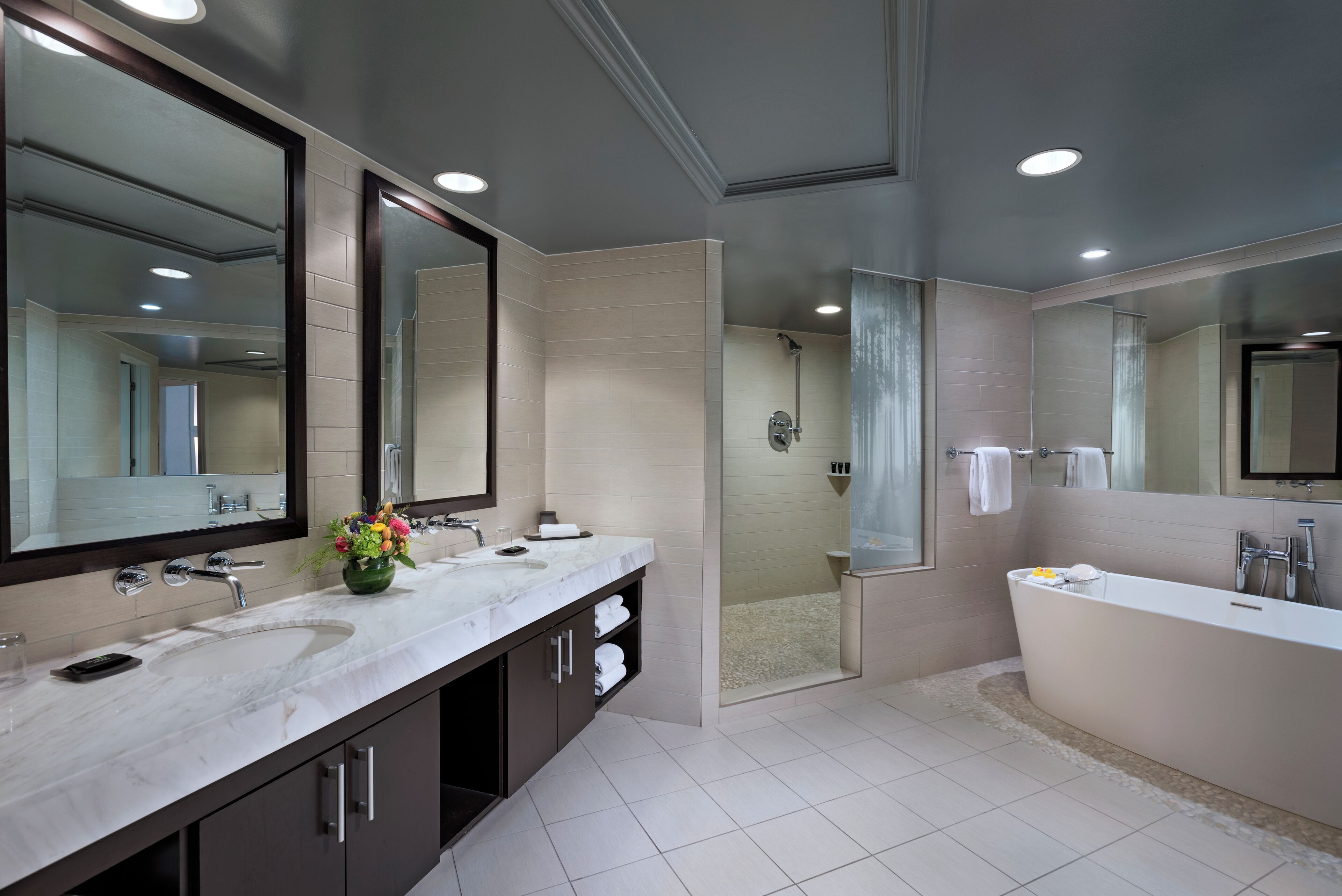 Une salle de bain moderne avec un grand lavabo, un miroir et une baignoire.