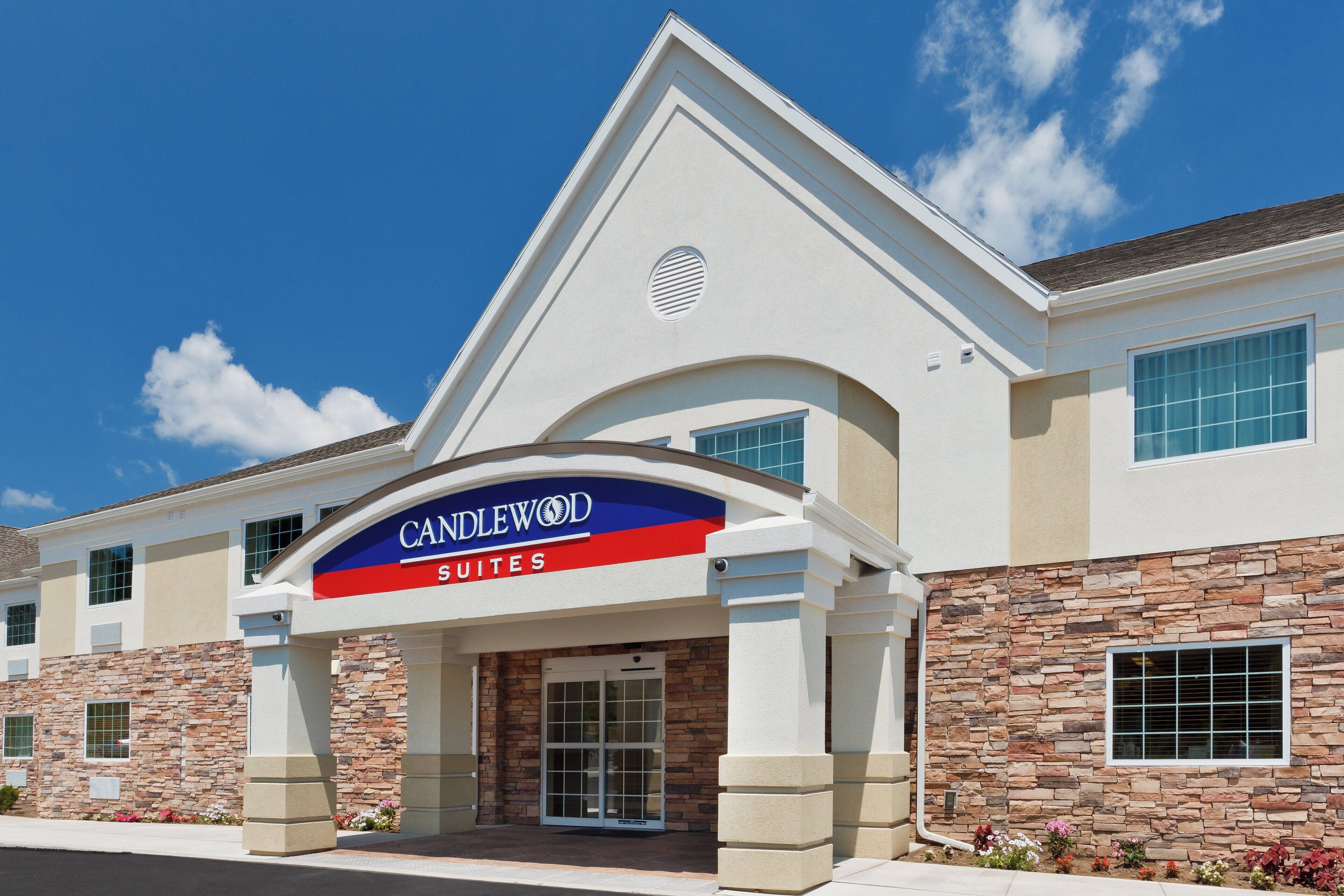 A hotel entrance with a sign reading 'CANDLEWOOD SUITES'.