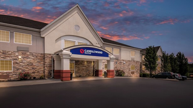 A hotel with a stone facade, a prominent entrance, and a clear sky. - Candlewood Suites HAZLETON by IHG (Sugarloaf)