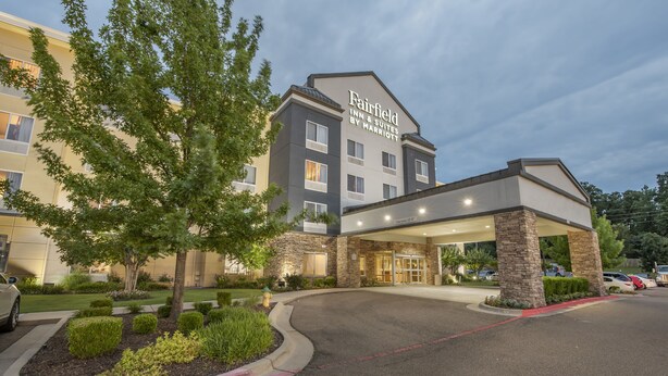 A Fairfield Inn & Suites by Marriott hotel with a modern design, featuring a stone facade, a covered entrance, and landscaped grounds. - Fairfield Inn & Suites by Marriott Texarkana (Texarkana)