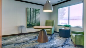 A room with a round table, a hanging light fixture, a painting, and two chairs. - Fairfield Inn & Suites by Marriott Texarkana (Texarkana)