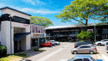 Un estacionamiento con varios coches, un edificio con el rótulo 'Ramstack' y una tienda 'Supermart'.