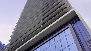 A tall, modern skyscraper with a grid-like facade and large windows.