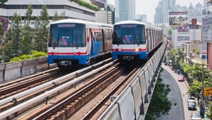 Two trains on elevated tracks with a cityscape in the background. - Grand Inn Hotel (Bangkok)