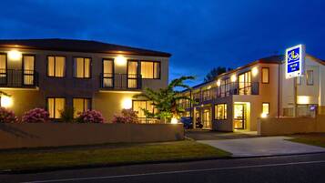 Stylish hotel with a flat roof and symmetrical facade, featuring windows and balconies.