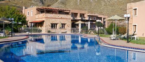 A swimming pool with a stone facade building in the background.