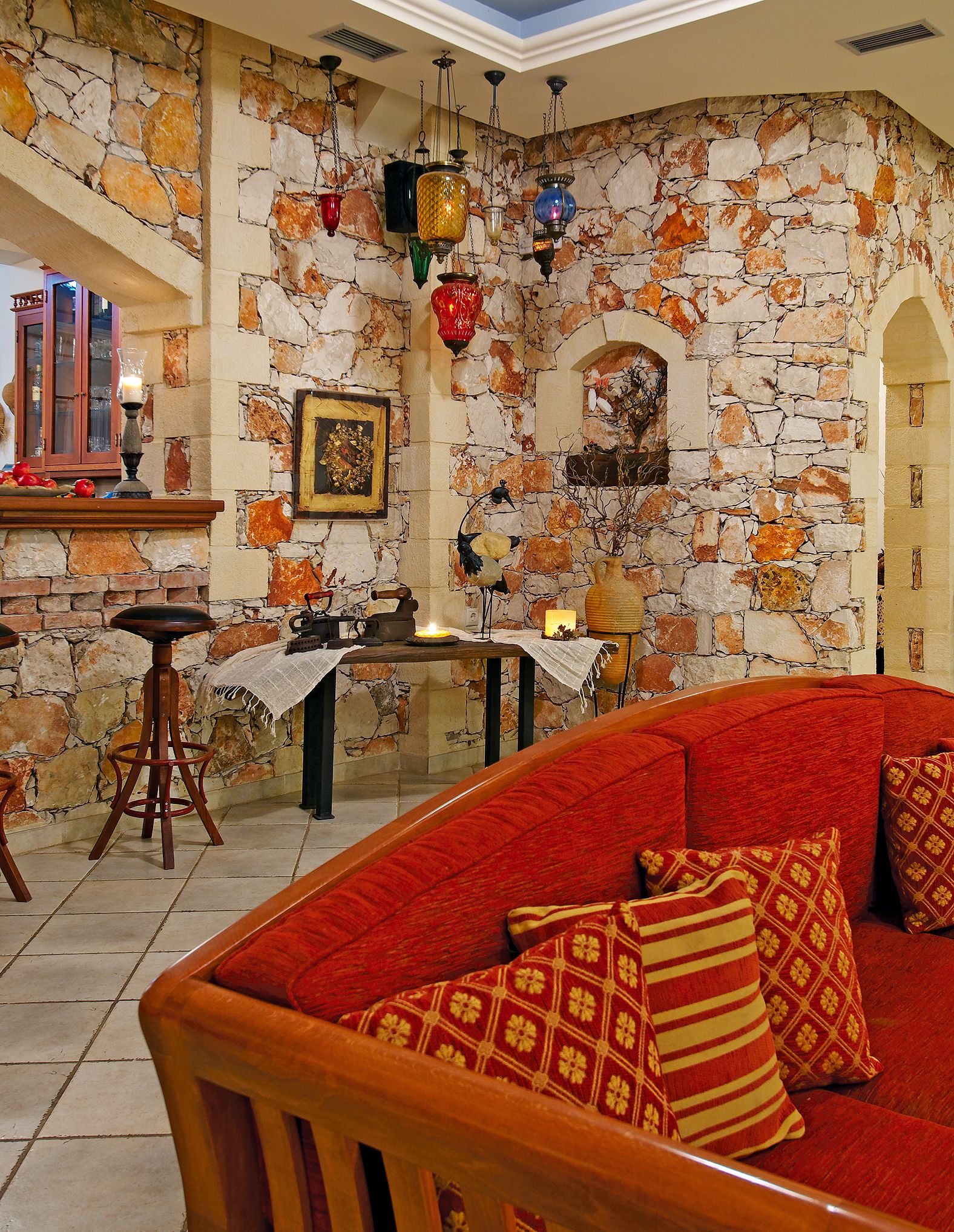Una sala de estar acogedora con una pared de piedra, un sofá rojo y una mesa de centro de madera.