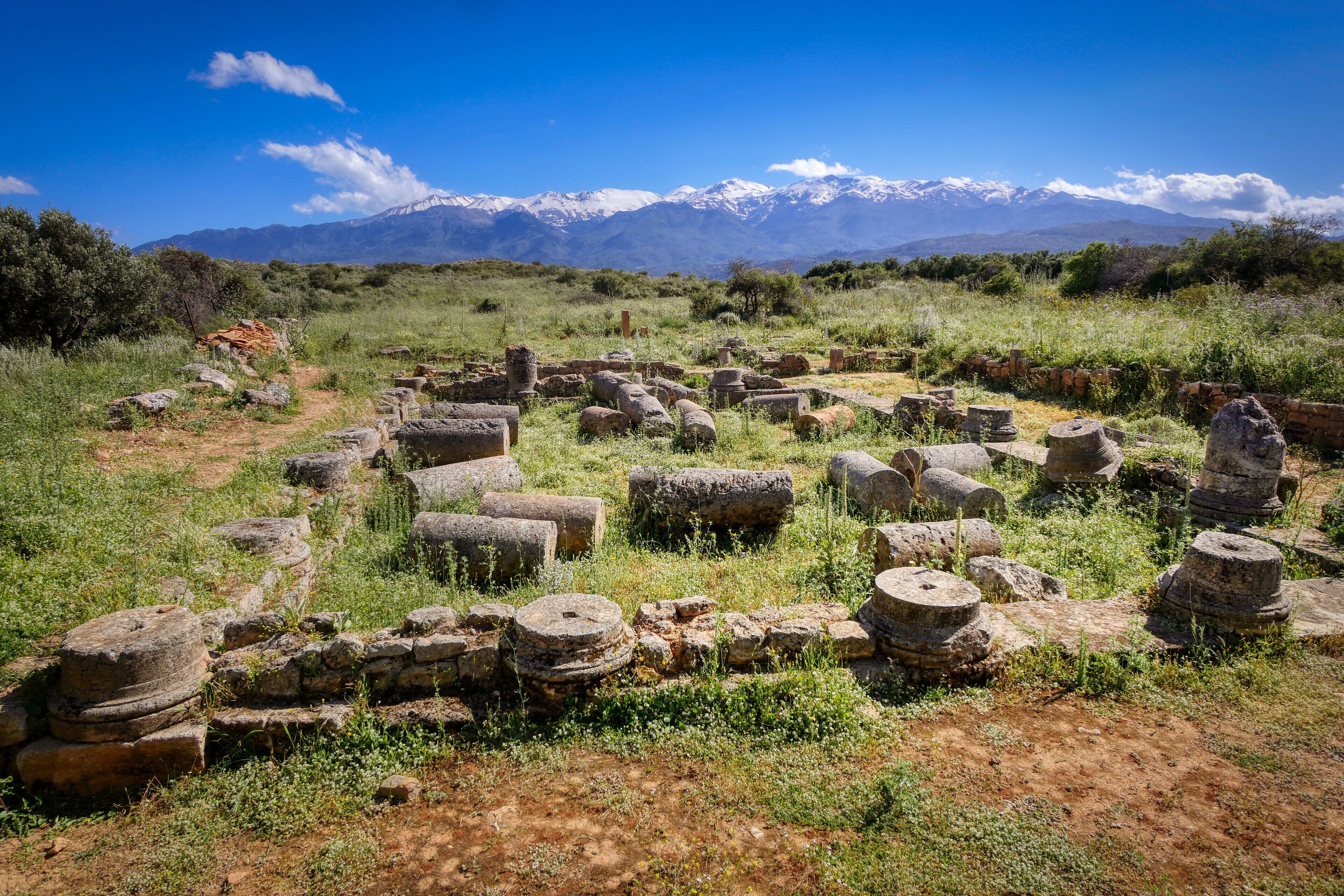 Ancient stone ruins with a mountainous backdrop.