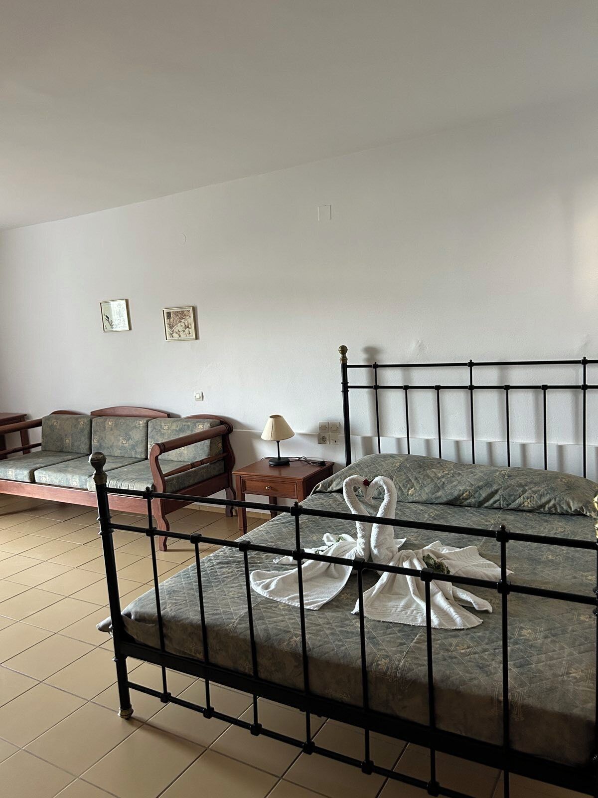 Ein Zimmer mit einem Bett, einem Sofa, einem Sessel und einem kleinen Tisch.