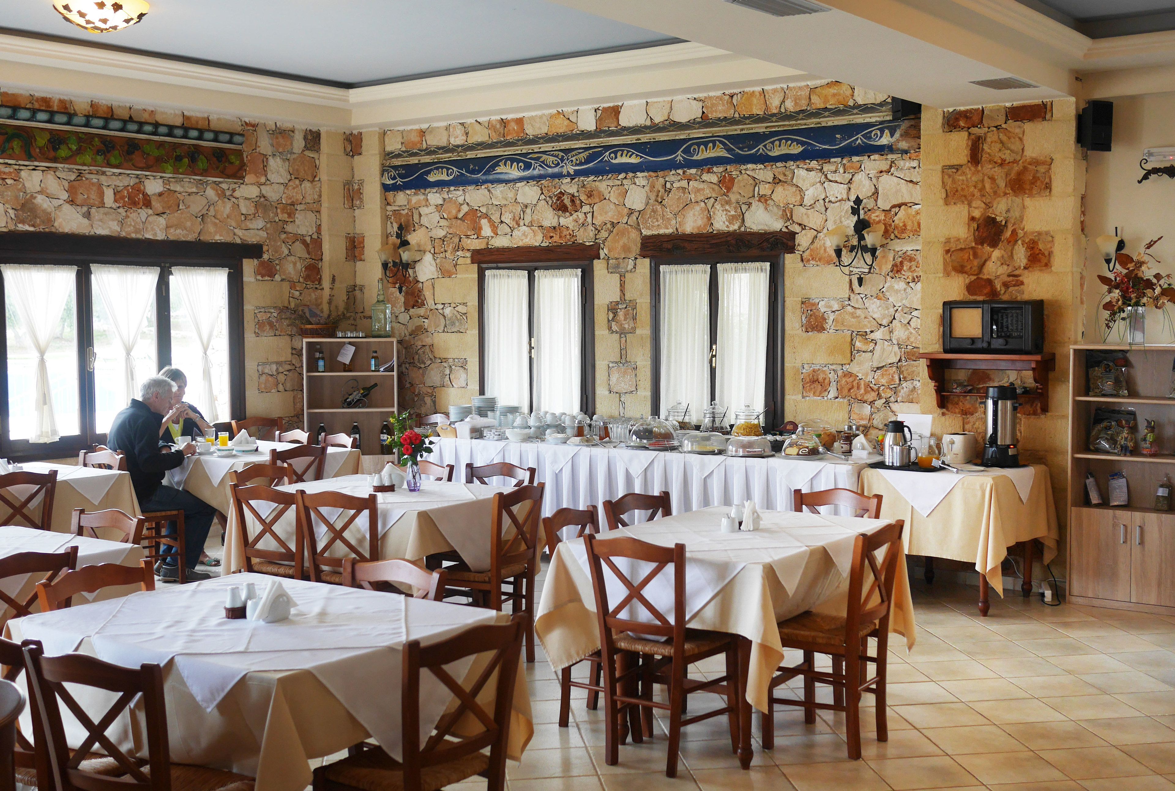 A restaurant with stone walls, multiple tables, and chairs.