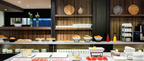 Un bufé con diversas opciones de comida y una estación de café.