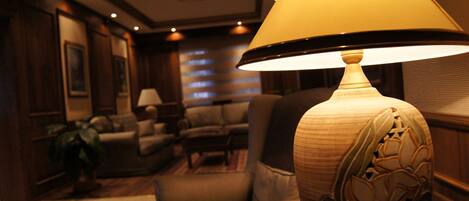 A well-lit living room with a large lamp, a sofa, and a coffee table.