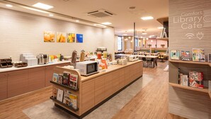 Een café in een bibliotheek met een houten toonbank, boekenplanken en een koffiehoek.
