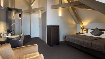 Una habitación de hotel moderna con una cama grande, un escritorio con espejo, una silla y un armario.