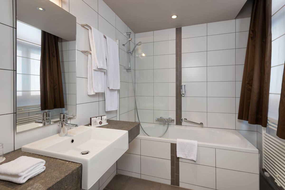 Un baño moderno con un lavamanos grande, una bañera y una ducha.